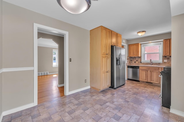 9623 Fairfield St, Livonia, MI 48150 - kitchen featuring appliances with stainless steel finishes, stone tile flooring, decorative backsplash, and plenty of natural light