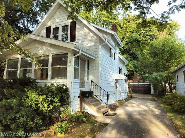 1828 N Lafayette Ave, Royal Oak, MI 48073 - view of front of home with a chimney, a detached garage, and a sunroom