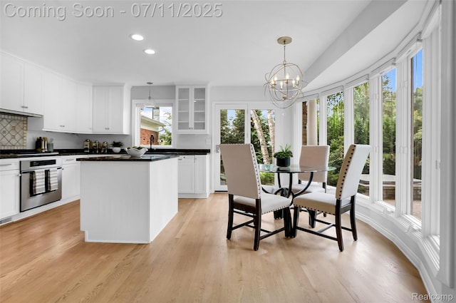 425 Fairfax St, Birmingham, MI 48009 - kitchen featuring stainless steel oven, dark countertops, glass insert cabinets, white cabinets, and a chandelier