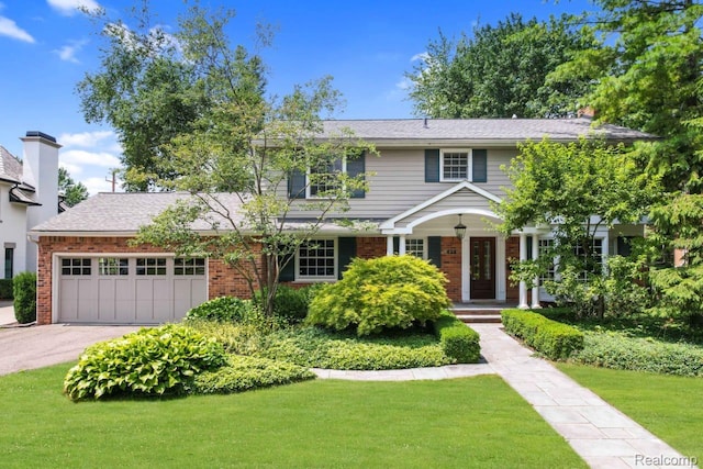 425 Fairfax St, Birmingham, MI 48009 - view of front of house featuring an attached garage, driveway, brick siding, and a front lawn