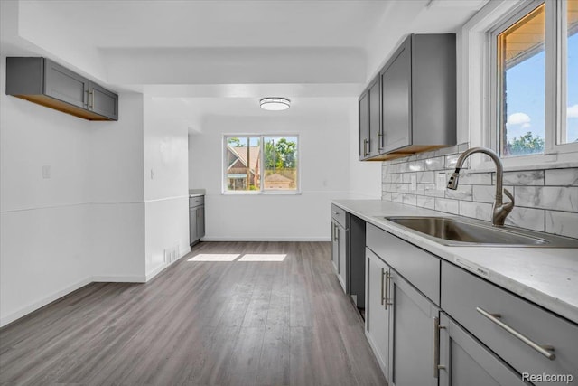 19155 Gallagher St, Detroit, MI 48234 - kitchen with gray cabinetry, wood finished floors, backsplash, and light countertops