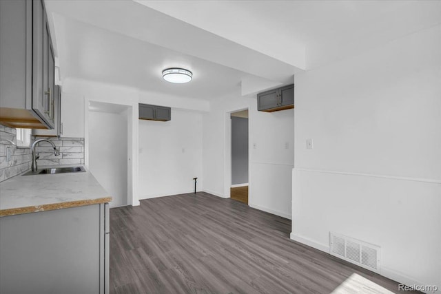 19155 Gallagher St, Detroit, MI 48234 - kitchen featuring light countertops, backsplash, dark wood-type flooring, and gray cabinetry