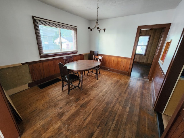 1110 Watkins St SE, Grand Rapids, MI 49507 - dining area featuring wainscoting, a chandelier, dark wood-style floors, and wood walls