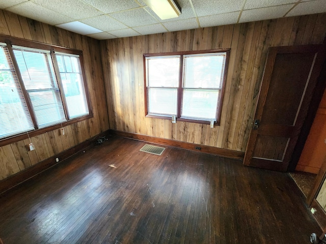 1110 Watkins St SE, Grand Rapids, MI 49507 - empty room featuring dark wood finished floors, a paneled ceiling, and wooden walls