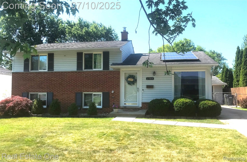 2344 Winston, Sterling Heights, MI 48310 - split level home with brick siding, roof mounted solar panels, and a chimney