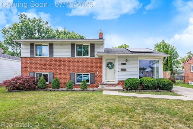 2344 Winston, Sterling Heights, MI 48310 - tri-level home with brick siding, a chimney, roof mounted solar panels, and a front lawn