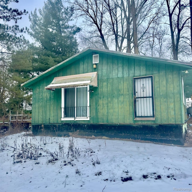 14108 Sheridan Rd, Montrose, MI 48457 - view of snow covered exterior with board and batten siding