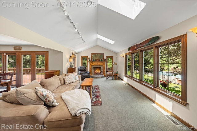 25740 Farmbrook Rd, Southfield, MI 48034 - living area with track lighting, a skylight, vaulted ceiling, a brick fireplace, and carpet flooring