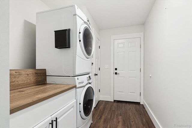 3416 Abbottsford Rd, Clyde, MI 48049 - washroom featuring estacked washer and dryer, cabinet space, and dark wood-style flooring