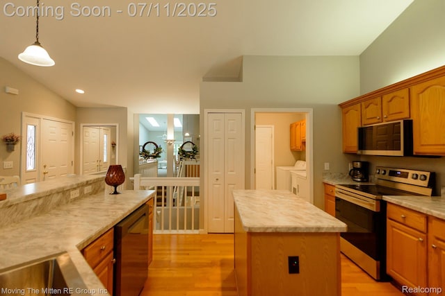 61001 Evergreen Ct, South Lyon, MI 48178 - kitchen with stainless steel appliances, independent washer and dryer, a center island, and light countertops