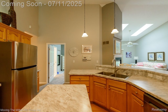 61001 Evergreen Ct, South Lyon, MI 48178 - kitchen featuring stainless steel appliances, high vaulted ceiling, a skylight, light countertops, and pendant lighting