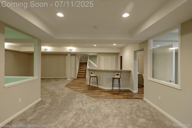 61001 Evergreen Ct, South Lyon, MI 48178 - unfurnished living room featuring carpet, stairs, recessed lighting, and a raised ceiling