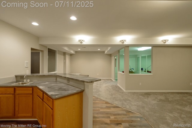 61001 Evergreen Ct, South Lyon, MI 48178 - kitchen featuring brown cabinetry, recessed lighting, open floor plan, light wood finished floors, and light carpet