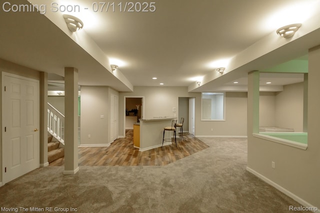 61001 Evergreen Ct, South Lyon, MI 48178 - finished basement with carpet flooring, stairway, bar area, and recessed lighting