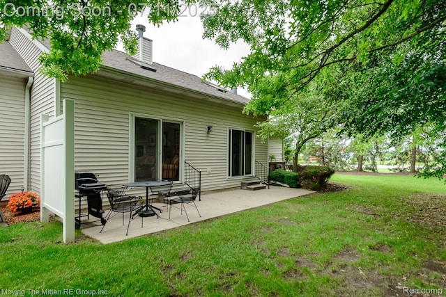 61001 Evergreen Ct, South Lyon, MI 48178 - rear view of house with entry steps, a lawn, a patio area, a chimney, and roof with shingles