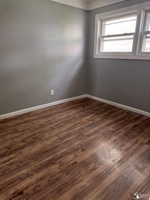 6114 Hazel St, Taylor, MI 48180 - spare room with baseboards and dark wood-type flooring