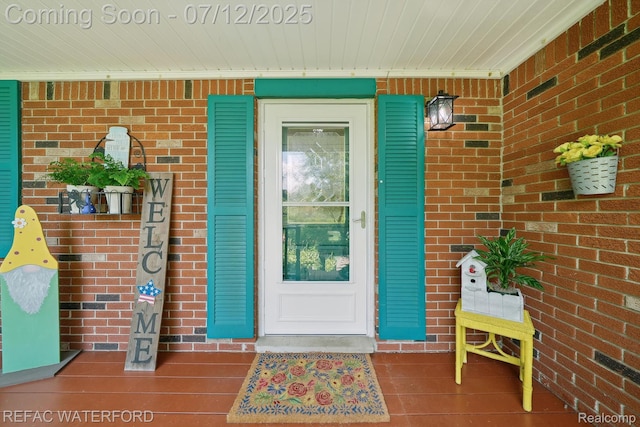 11857 Ely Rd, Davisburg, MI 48350 - view of exterior entry featuring brick siding and covered porch