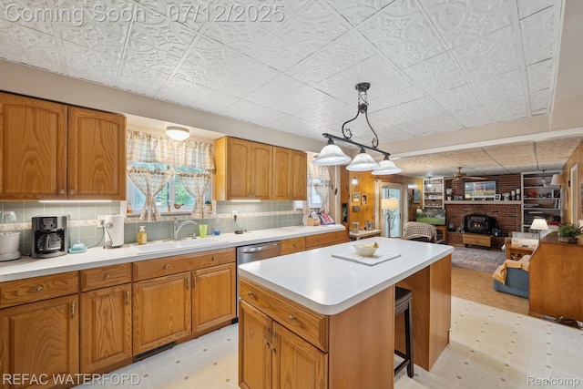 11857 Ely Rd, Davisburg, MI 48350 - kitchen featuring a center island, stainless steel dishwasher, light countertops, open floor plan, and brown cabinetry