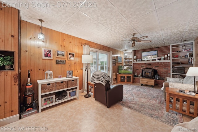 11857 Ely Rd, Davisburg, MI 48350 - living room with wooden walls, a ceiling fan, and a wood stove
