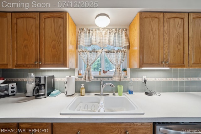 11857 Ely Rd, Davisburg, MI 48350 - kitchen with stainless steel dishwasher, brown cabinets, tasteful backsplash, and light countertops