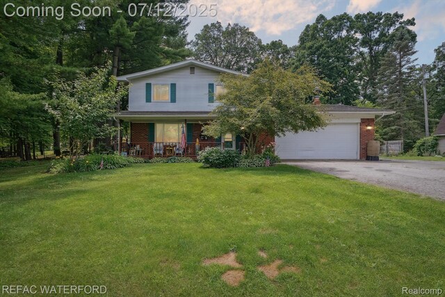 11857 Ely Rd, Davisburg, MI 48350 - view of front of property with driveway, covered porch, brick siding, a front lawn, and a garage