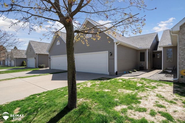 9164 Emily Dr, Davison, MI 48423 - view of side of property featuring concrete driveway, an attached garage, and roof with shingles