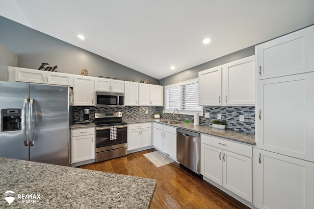 9164 Emily Dr, Davison, MI 48423 - kitchen featuring appliances with stainless steel finishes, lofted ceiling, backsplash, white cabinets, and recessed lighting