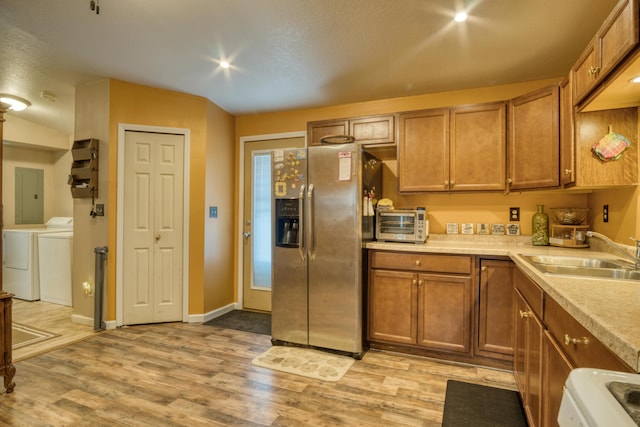 4180 15 Mile Rd, Barryton, MI 49305 - kitchen featuring stainless steel fridge with ice dispenser, washing machine and clothes dryer, brown cabinetry, and light wood finished floors