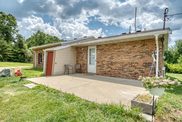4180 15 Mile Rd, Barryton, MI 49305 - rear view of house featuring a patio area, brick siding, and a yard