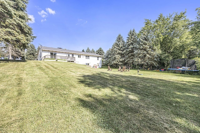 14555 Fruit Ridge Ave, Kent City, MI 49330 - view of green lawn featuring a trampoline and a deck