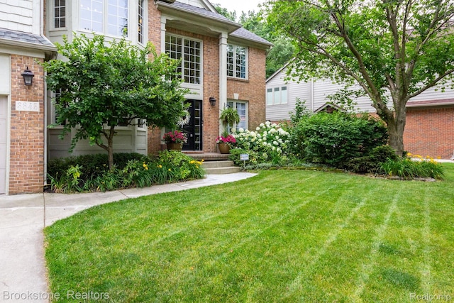 3845 Beechcrest, Rochester Hills, MI 48309 - view of exterior entry featuring brick siding and a lawn