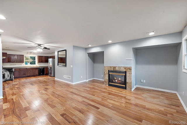 8873 Lagoon Dr, Brighton, MI 48116 - unfurnished living room featuring light wood-style floors, ceiling fan, a fireplace, and recessed lighting