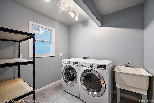 8873 Lagoon Dr, Brighton, MI 48116 - laundry room featuring independent washer and dryer, light wood-style floors, and track lighting