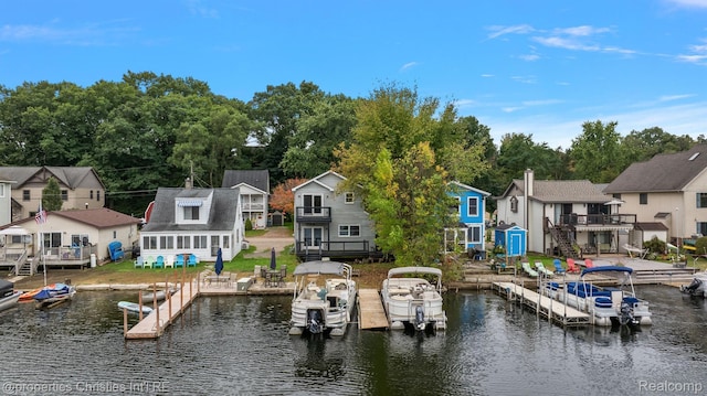 8873 Lagoon Dr, Brighton, MI 48116 - dock featuring a residential view, a deck with water view, and view of wooded area