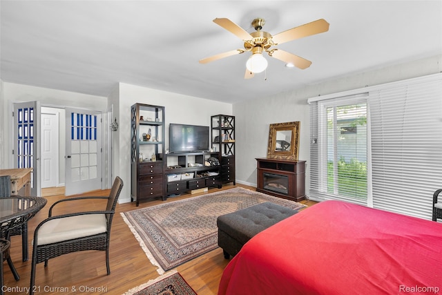 45055 Mcbride Ave, Van Buren, MI 48111 - bedroom featuring wood finished floors, a glass covered fireplace, and a ceiling fan