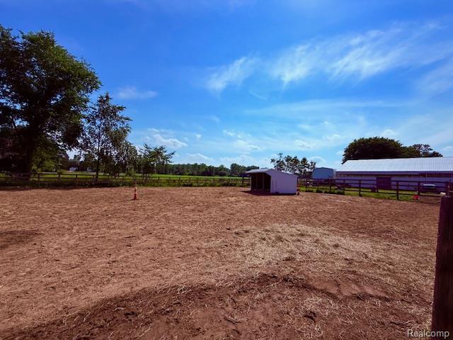3120 Bruisee Rd, Marlette, MI 48723 - view of yard with a view of countryside, an outdoor structure, and an enclosed riding area