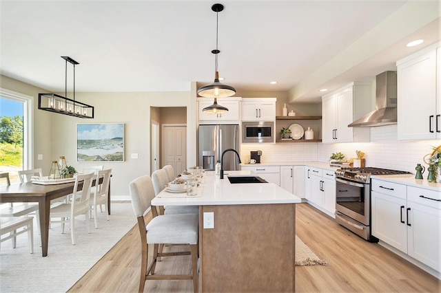 9088 N 34th St, Richland, MI 49083 - kitchen with stainless steel appliances, wall chimney range hood, open shelves, light wood finished floors, and tasteful backsplash
