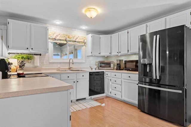 5160 Barker Rd, Jonesville, MI 49250 - kitchen featuring black appliances, decorative backsplash, light countertops, and white cabinetry