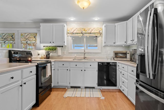 5160 Barker Rd, Jonesville, MI 49250 - kitchen featuring black appliances, decorative backsplash, white cabinetry, and light countertops