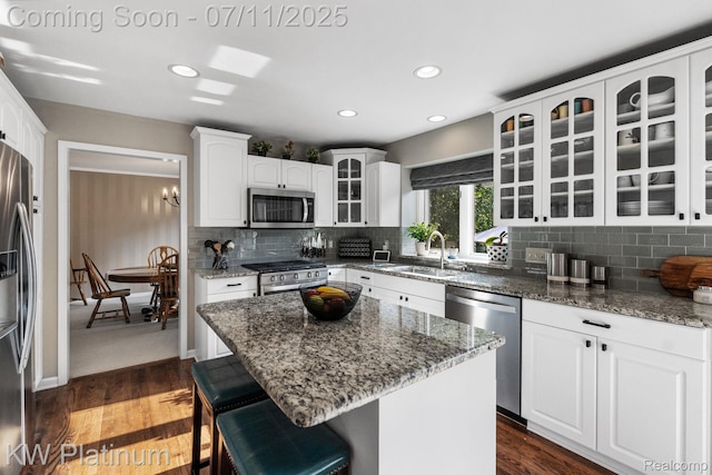 4317 Vassar Dr, Troy, MI 48085 - kitchen featuring stainless steel appliances, a breakfast bar area, decorative backsplash, white cabinetry, and recessed lighting