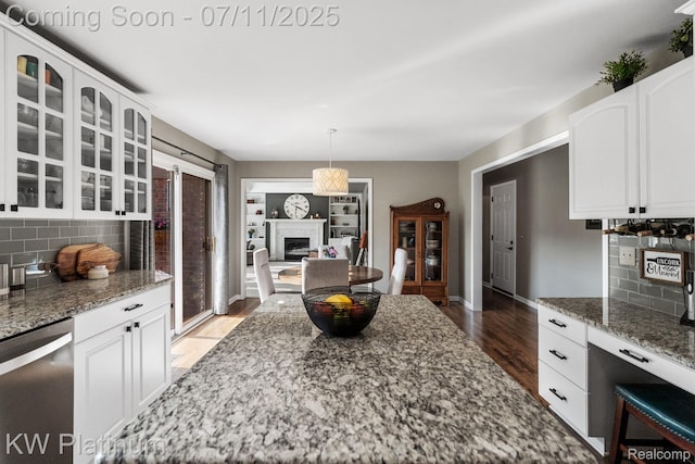 4317 Vassar Dr, Troy, MI 48085 - kitchen featuring stainless steel dishwasher, wood finished floors, glass insert cabinets, and tasteful backsplash