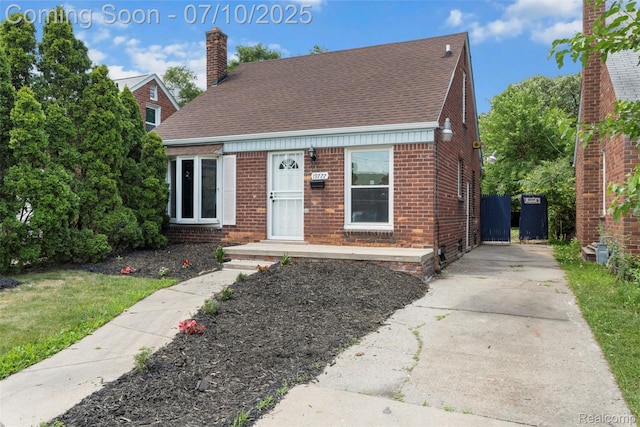 19777 Santa Rosa Dr, Detroit, MI 48221 - view of front of house with brick siding, a chimney, driveway, and roof with shingles