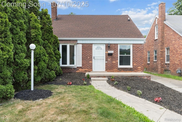 19777 Santa Rosa Dr, Detroit, MI 48221 - cape cod home featuring a chimney, a shingled roof, brick siding, and a front lawn