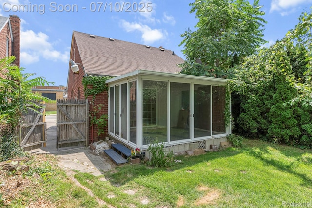 19777 Santa Rosa Dr, Detroit, MI 48221 - view of home's exterior with a sunroom, a shingled roof, a yard, a gate, and brick siding