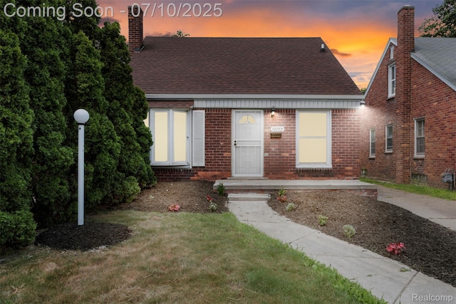 19777 Santa Rosa Dr, Detroit, MI 48221 - new england style home with a chimney, roof with shingles, brick siding, and a yard