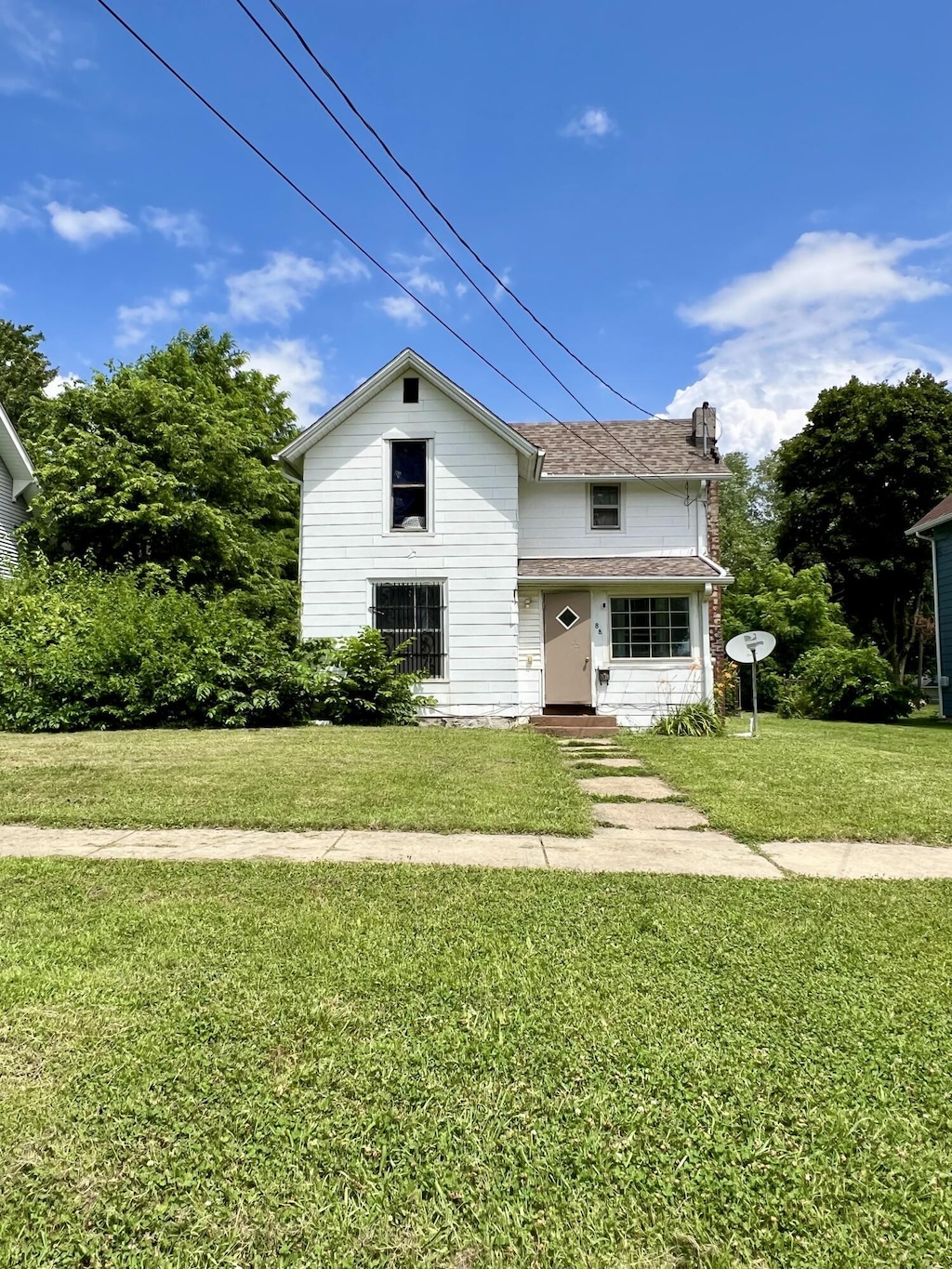 88 Battle Creek Ave, Battle Creek, MI 49037 - traditional-style house featuring a front lawn and a chimney