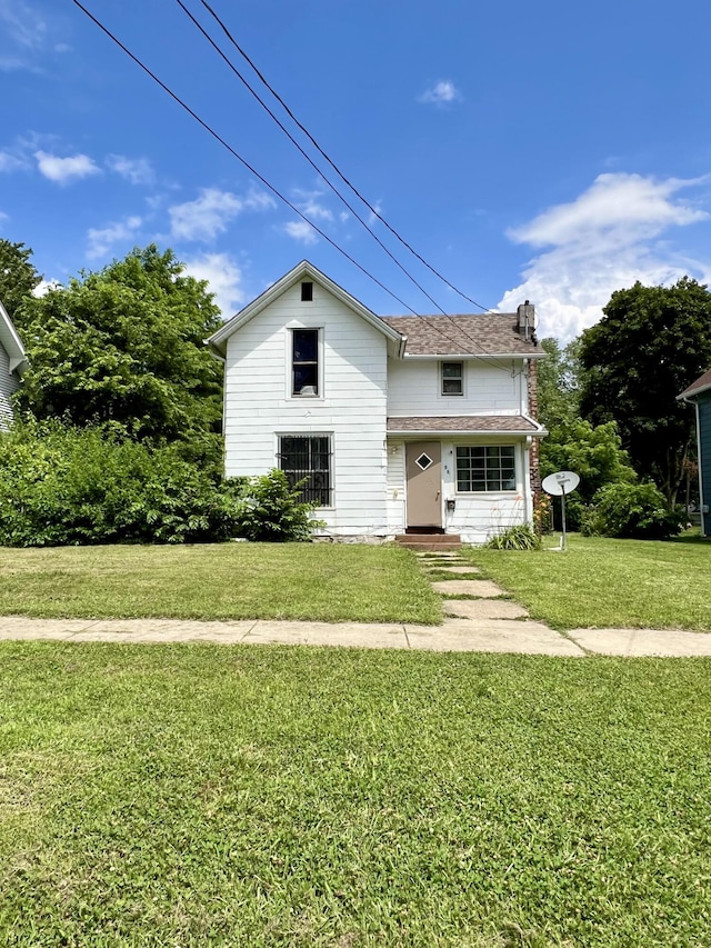 88 Battle Creek Ave, Battle Creek, MI 49037 - traditional-style house featuring a front lawn and a chimney