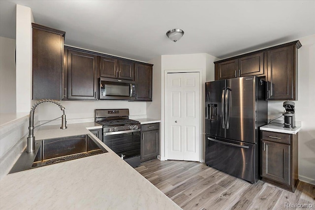 58565 Westmoore Cir, New Haven, MI 48048 - kitchen featuring stainless steel appliances, light wood-style flooring, dark brown cabinetry, and light countertops