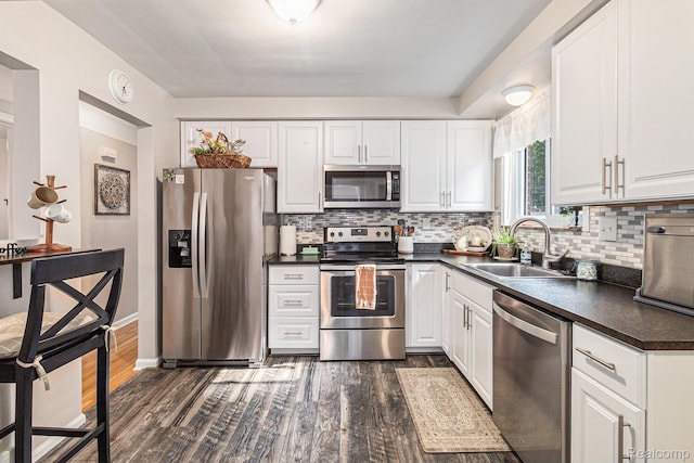 1820 W Longmeadow Rd, Trenton, MI 48183 - kitchen with stainless steel appliances, dark countertops, dark wood finished floors, and tasteful backsplash