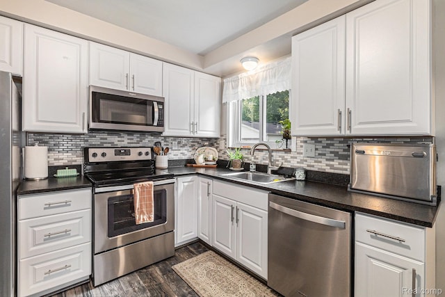 1820 W Longmeadow Rd, Trenton, MI 48183 - kitchen featuring appliances with stainless steel finishes, dark countertops, white cabinetry, and dark wood finished floors
